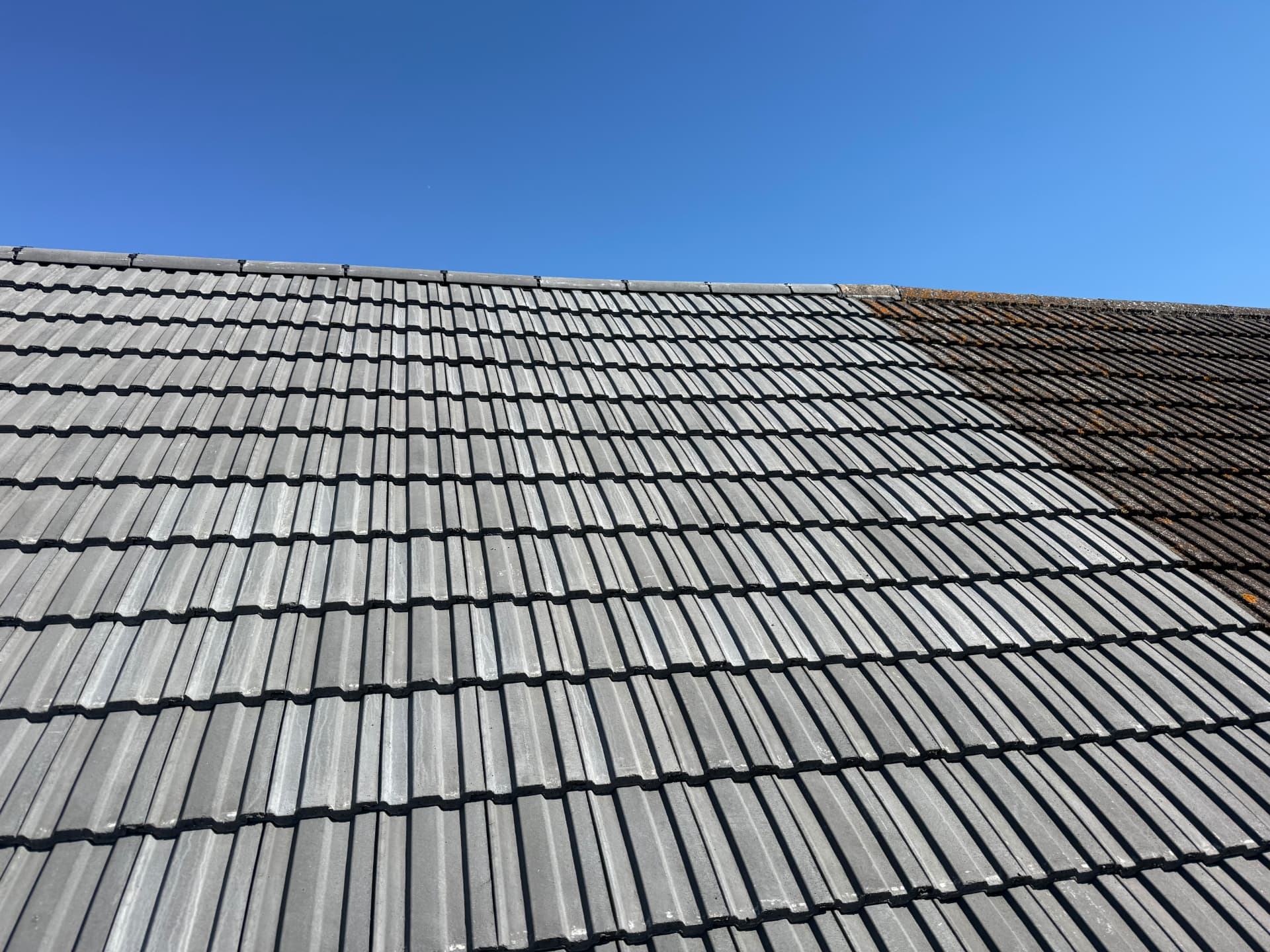 Grey interlocking tiled pitched roof compared with the old covering